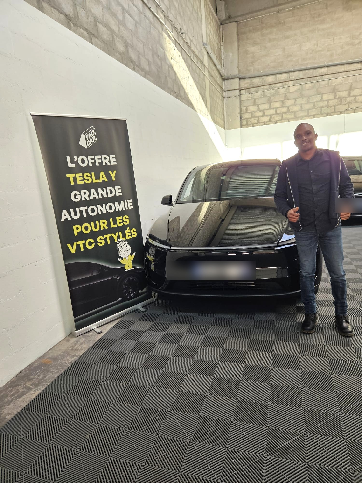 Omar, chauffeur VTC fondateur d'Oums VTC, aux côtés de sa Tesla Model Y